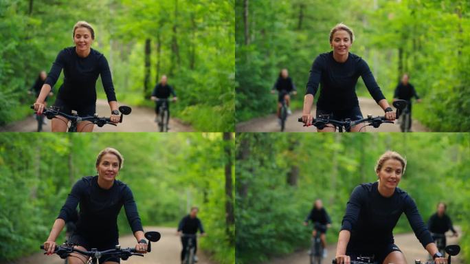 美丽的中年妇女骑自行车在森林里，肖像在运动，享受速度和风