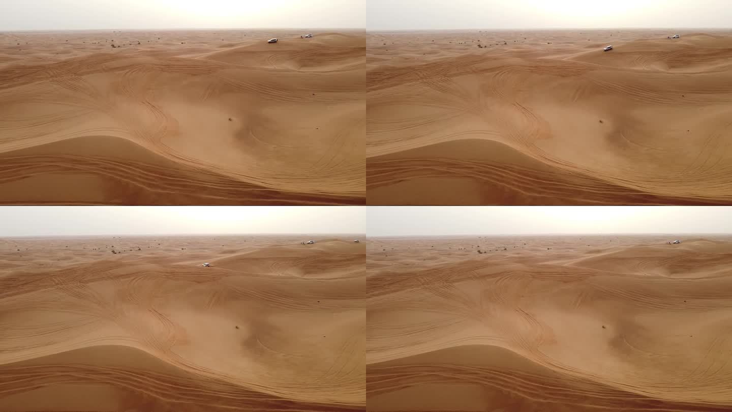 在迪拜沙漠的沙丘上行驶的汽车鸟瞰图。