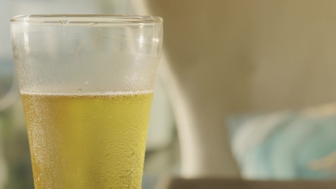 在夏日明媚的阳光下，一杯冰镇的、自酿的啤酒，金黄色的、冰凉的液体闪烁着一种闪闪发光的魅力，杯子里折射