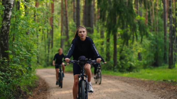 夏日，女游客在美丽的森林里骑自行车，在大自然中骑自行车旅行