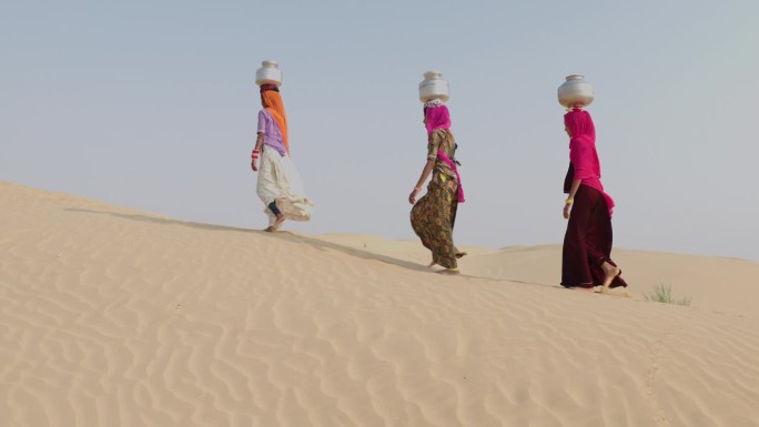 印度沙漠村庄，年轻女孩从井里打水