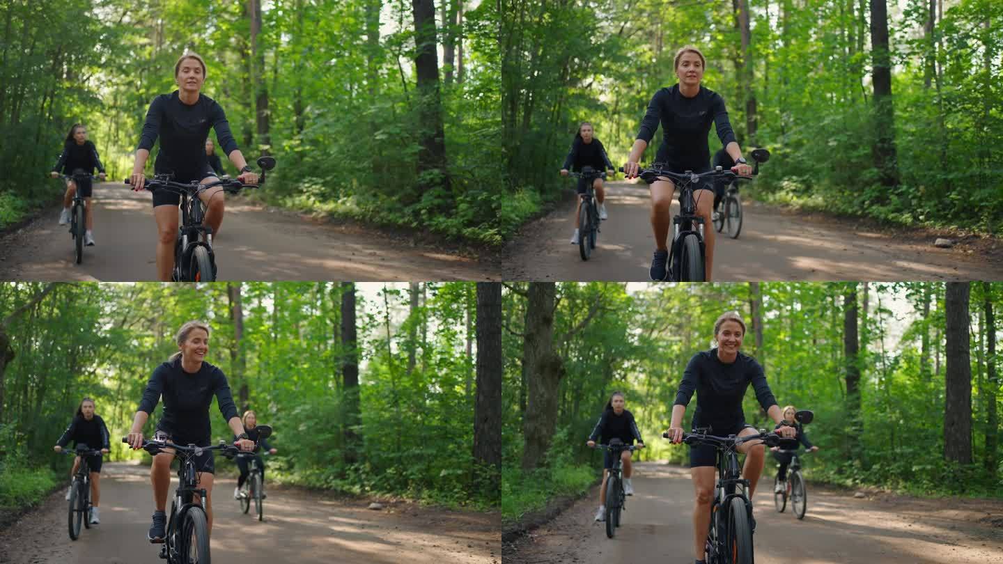 年轻女子在大自然中骑自行车，女性朋友一起在阳光明媚的森林里骑自行车
