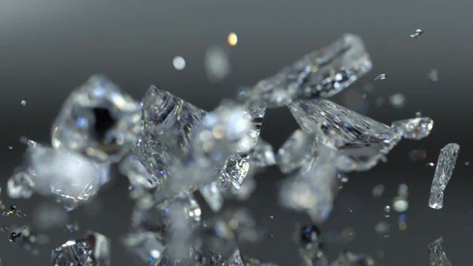 钻石形状的晶体在粗糙的表面上快速落下，并在慢动作中破碎成碎片