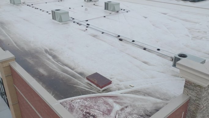 屋顶损坏被白色防水布覆盖，空中动态