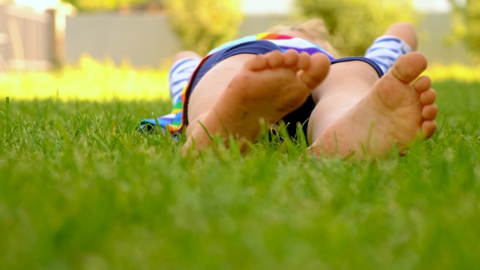 孩子的脚踩在公园的草地上。有选择性的重点。
