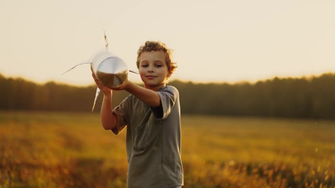 未来宇航员的肖像，夏天在草地上玩玩具火箭的小男孩，慢镜头