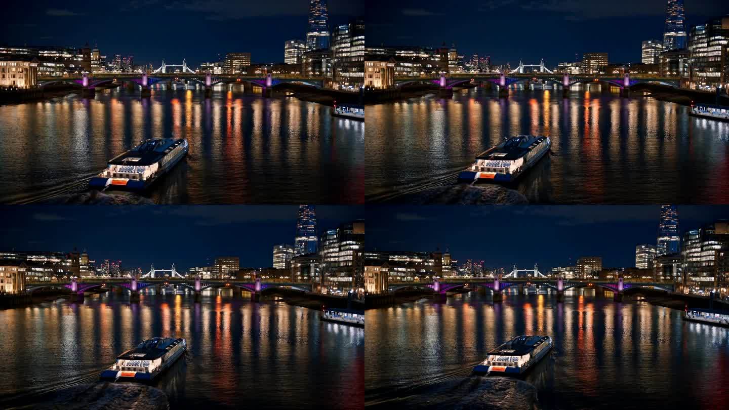 英国伦敦泰晤士河的夜景。漂浮的船，远处的桥梁和塔桥，两侧的碎片摩天大楼等建筑，照明很多