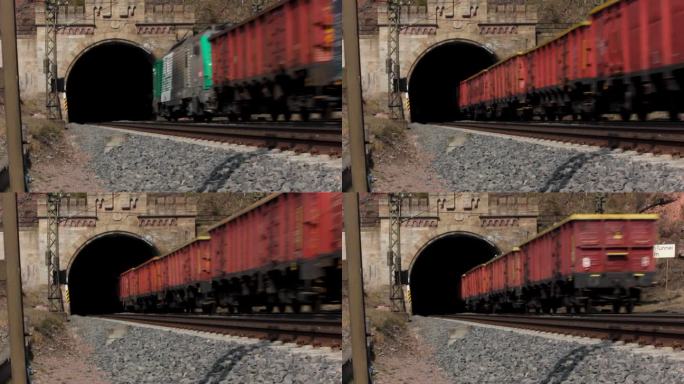 载着卡车的货运列车驶入漆黑的隧道，静止的铁路镜头