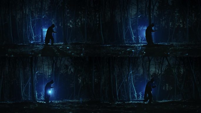 一个披着斗篷、戴着兜帽的黑影出现在阴森的夜林中。夜晚幻想的恶魔或女巫。