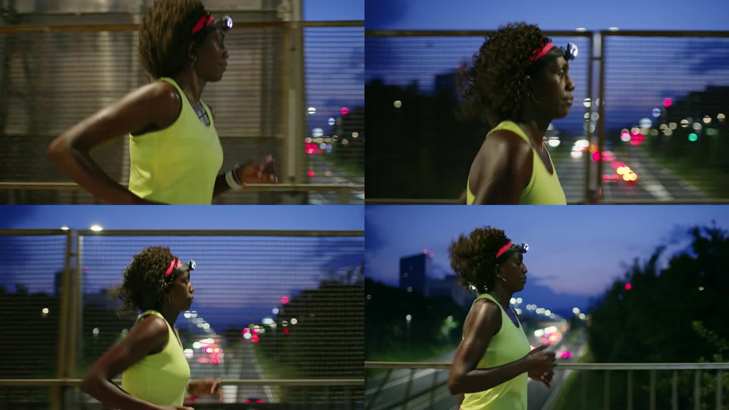 SLO MO TS运动黑人妇女晚上在城市跑步，戴着头灯