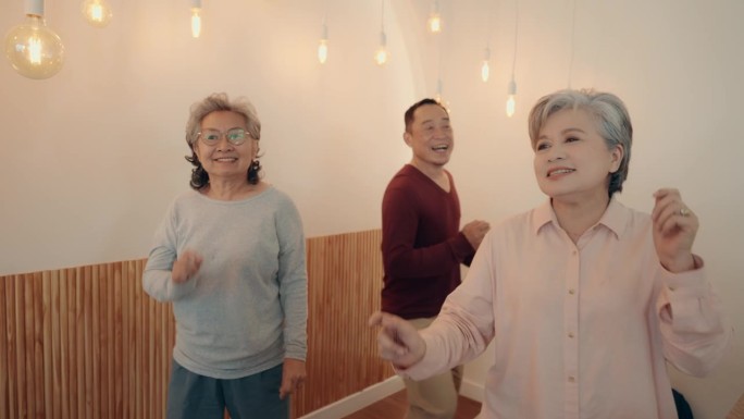 亚洲老年朋友在家跳舞自拍庆祝幸福。