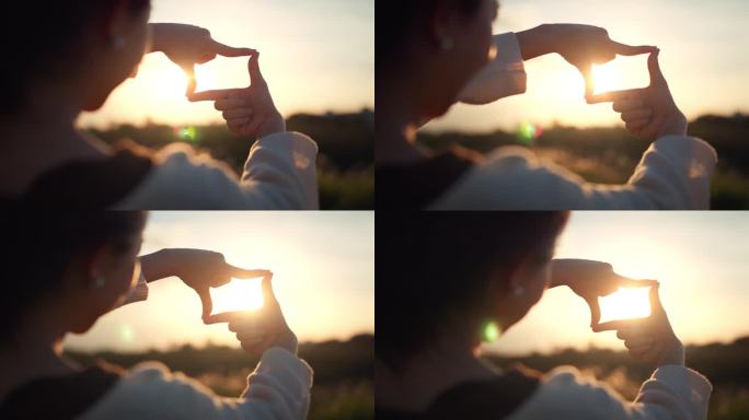 B卷——旅行自由的一个概念，近距离拍摄旅行者女性的手与夏日夕阳的相框手势，女性捕捉日出