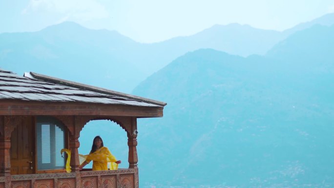 在印度喜马偕尔邦的马纳里，印度游客女孩站在纳格尔城堡，背景是山脉。旅游度假概念。