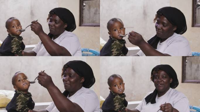 可爱宝宝吃东西的慢动作镜头。微笑的母亲给儿子喂饭。他们正坐在门廊旁。正在喂婴儿
