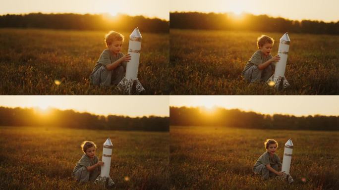 夏天，小男孩在田野里玩纸做的玩具火箭，把飞船抛向空中