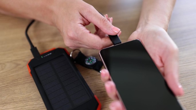 人将太阳能充电宝与手机连接