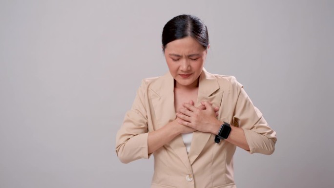 患有胸痛的亚洲妇女孤立地站在白色背景上。