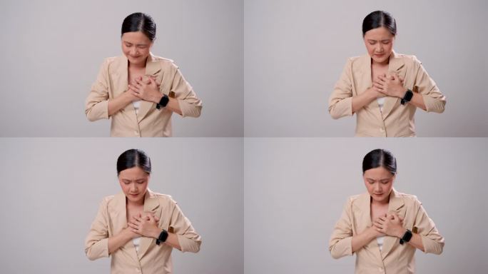 患有胸痛的亚洲妇女孤立地站在白色背景上。