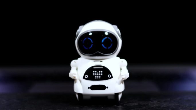 真正的白色小机器人在黑色的桌子上闪烁着眼睛。未来科技。业务发展助手。