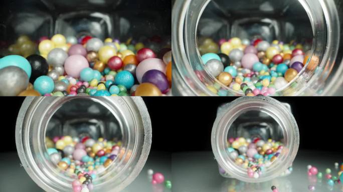 彩釉糖球罐。从内部看，球散落在桌子上对一个黑色的背景。多莉滑块极端特写。