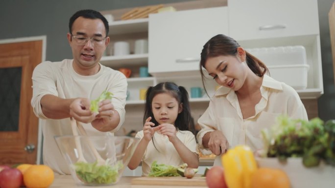 快乐的家庭时刻:父母教孩子准备新鲜蔬菜沙拉的艺术。