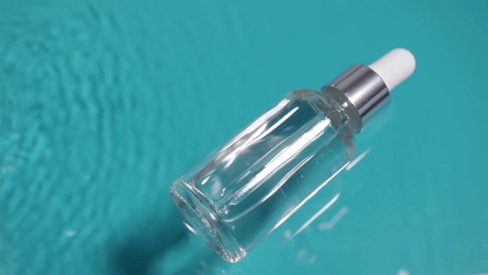 一瓶精华液，用于滋润面部肌肤的流动蓝色水，健康美容化妆品