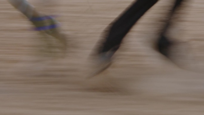 马蹄在沙质跑道上疾驰。慢镜头，慢快门速度。