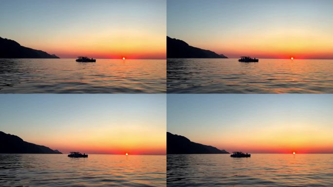 日落时航行船的剪影，太阳在地平线上