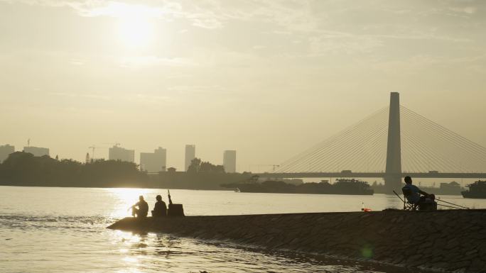 佛山龙湾大桥夕阳西下河岸边垂钓鱼的人