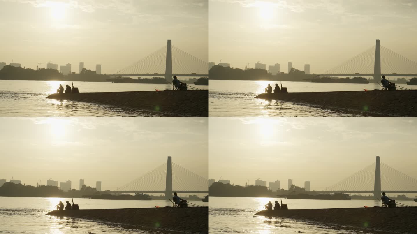 佛山龙湾大桥夕阳西下河岸边垂钓鱼的人