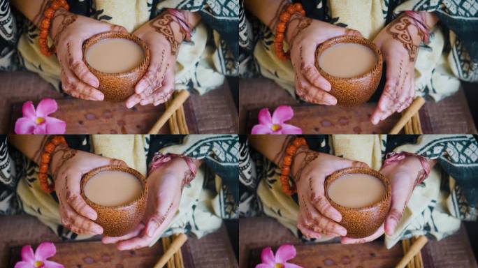 印度妇女手捧木杯的印度茶。关闭了。