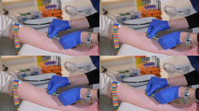 戴着手套的护士用针从病人的静脉中抽血。
