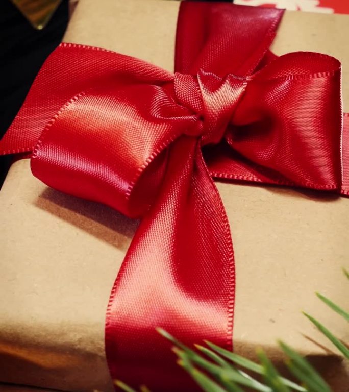 圣诞礼品盒配红丝带，衬托圣诞装饰。垂直视频