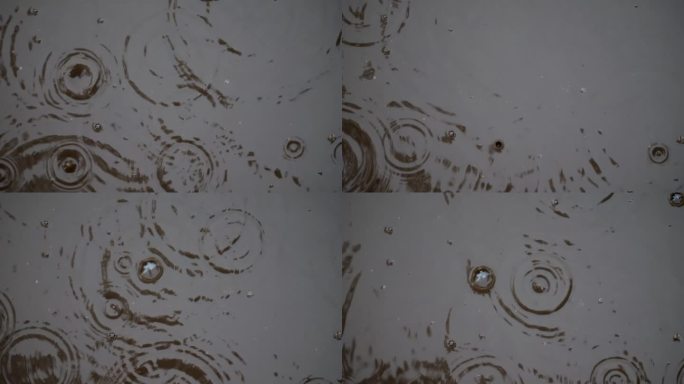 鸟瞰图:缓慢的雨滴击中水坑;形成有特色的气泡，反映出秋天的树木和天空。
