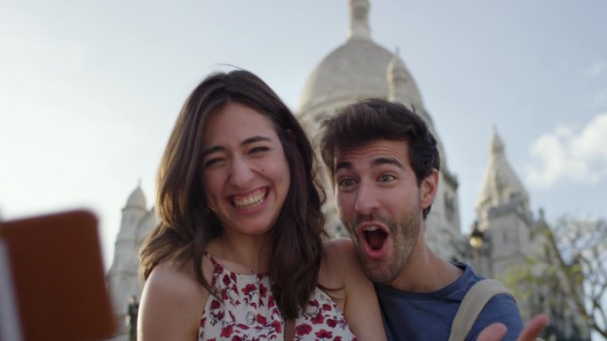 一对游客夫妇在巴黎圣心大教堂用智能手机自拍，享受暑假欧洲度假旅行冒险