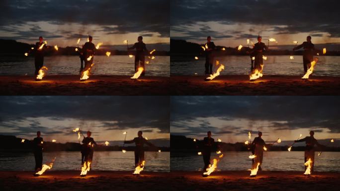 性感的女士们在湖滩上用火表演，慢动作，自然中的火表演