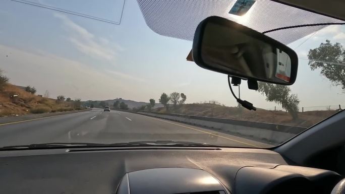 汽车在高速公路上快速移动的前视图，通过仪表盘摄像头的视角。