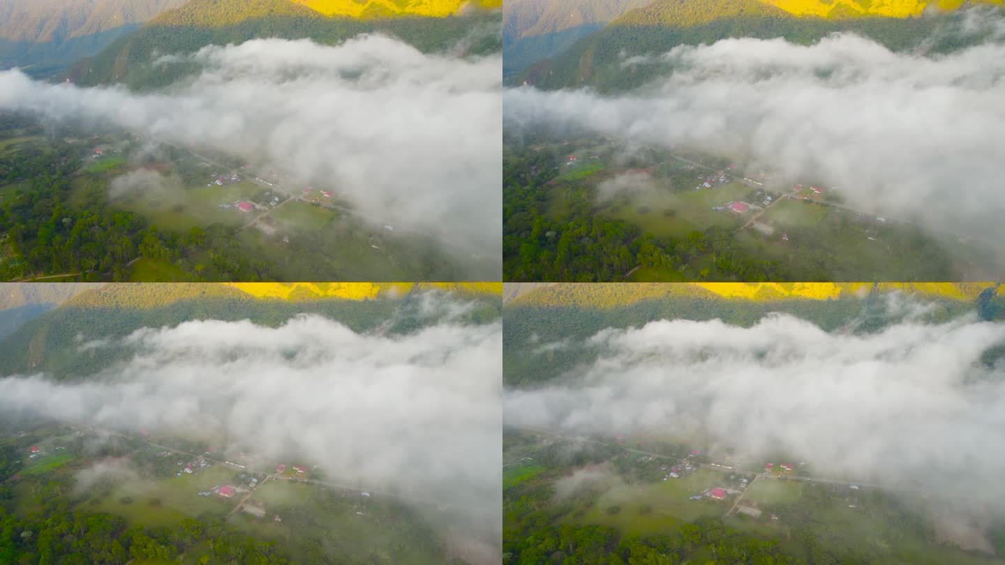 从无人机高角度拍摄的秘鲁奥克斯帕帕村的早晨。一个180度的旋转镜头显示了笼罩在云层中的村庄，房屋，郁