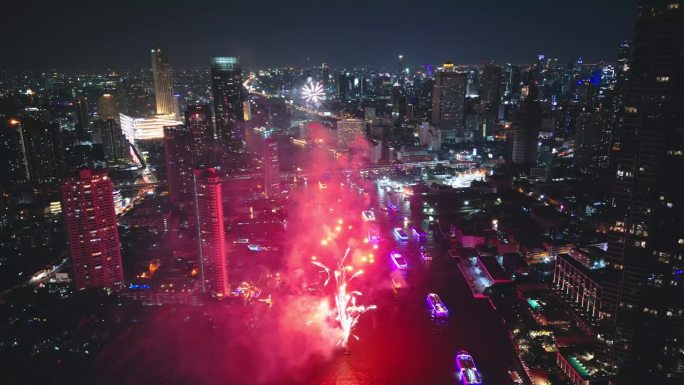 多色烟花在城市和摩天大楼上表演，庆祝夜晚的灯光、河流和曼谷大桥