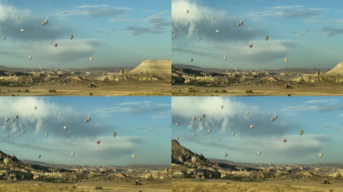 卡帕多西亚，日出时热气球飞过群山，从路过的车窗看过去。