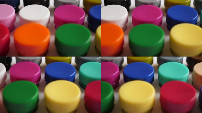 设置水粉颜料在罐子明亮的颜色接近。一套多色水粉画在塑料罐上。多莉拍摄多色背景。多色涂料的背景。创意绘