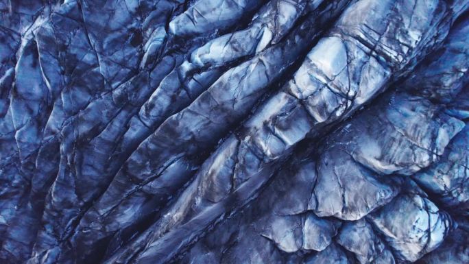 航拍:降落到冰川深处的裂缝和锯齿状的冰层，这是气候变化对这个自然奇观不断移动和转变的影响的证据。