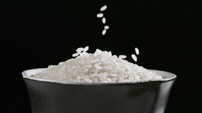 大米洒落到日式碗中 大米洒落到碗中特写
