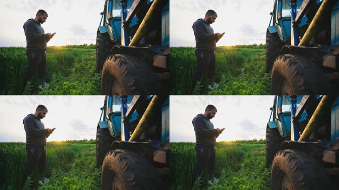 田地里的人拿着电话站在拖拉机旁敲打车轮，检查机器状况以诊断设备的可用性。经营一家卖农产品的小公司。