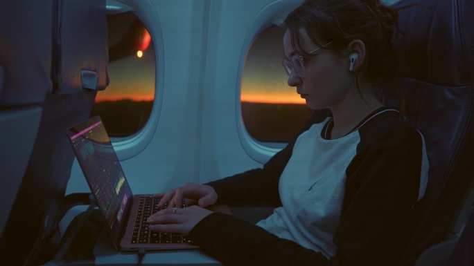在飞机上用笔记本电脑工作的女人