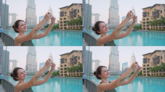 一名女子在迪拜喷泉附近用智能手机拍照