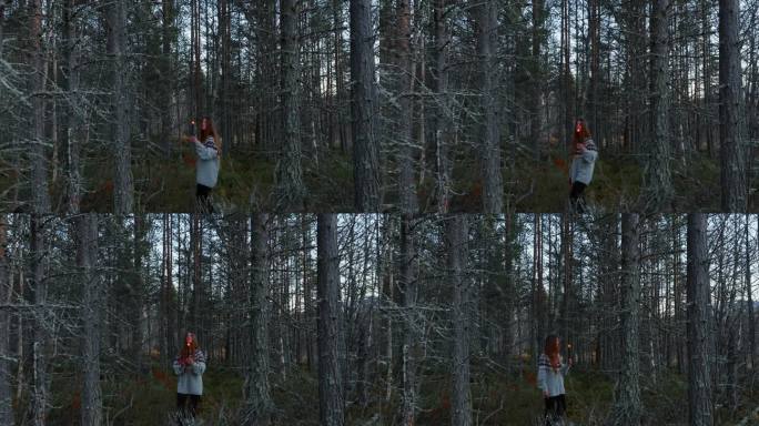 一个女人手拿蜡烛走在黑暗的挪威森林里