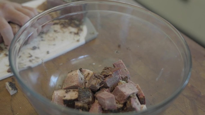 慢动作，切成方块的牛肉被扔进碗里