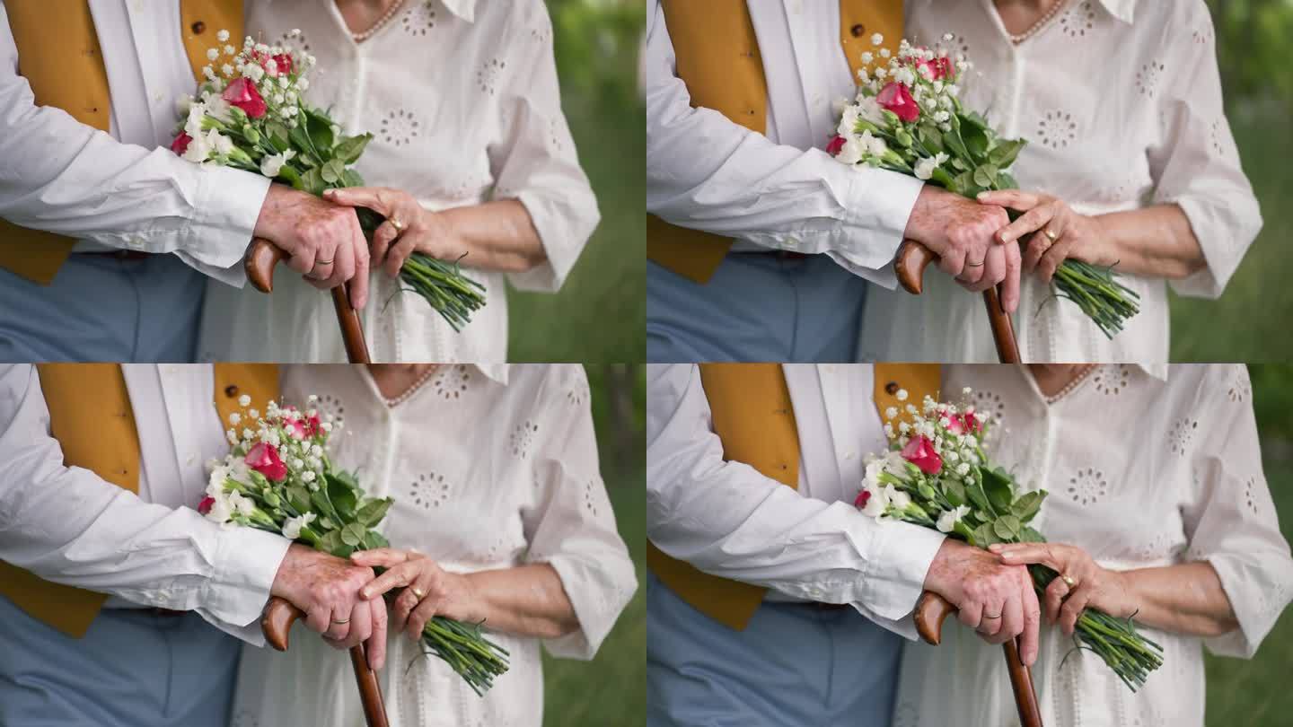 婚礼中，手拿结婚花束和结婚戒指的老人。