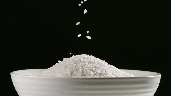 大米洒落到白色碗中 大米洒落到日式碗中